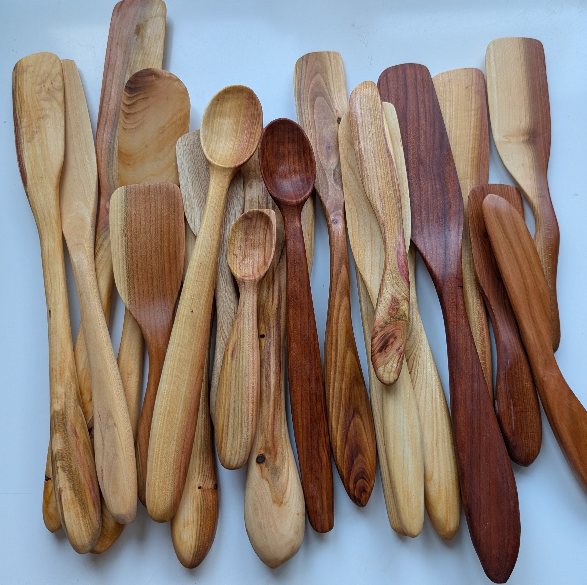 Mixed collection of hand-carved wooden spoons, spatulas and spreaders in reclaimed fruitwood