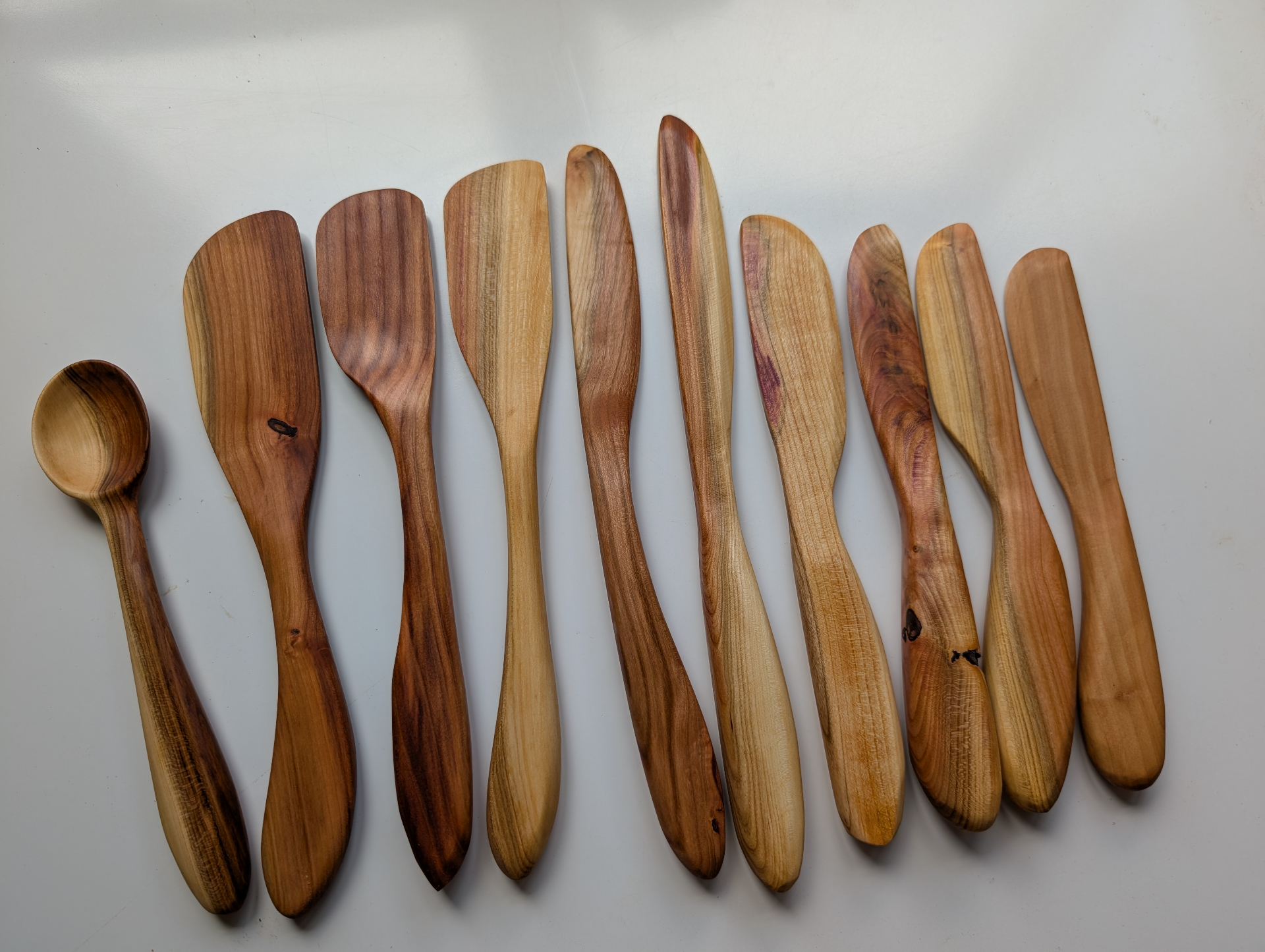 Row of handcarved wooden spatulas and butter spreaders