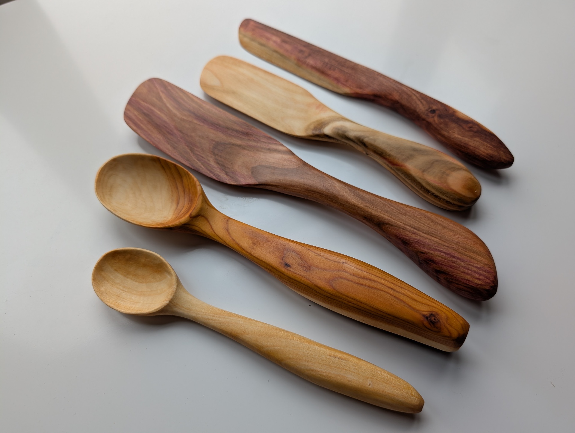 Handcarved wooden spoons, spatulas and butter knives in cherry and plum