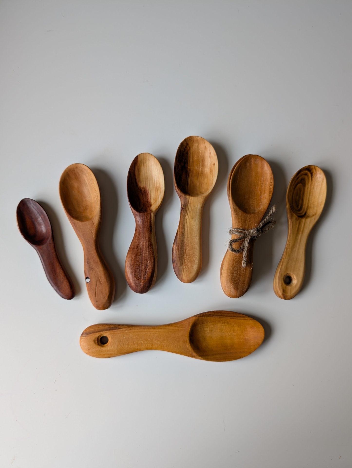 Collection of handcarved wooden coffee scoops in various fruitwoods