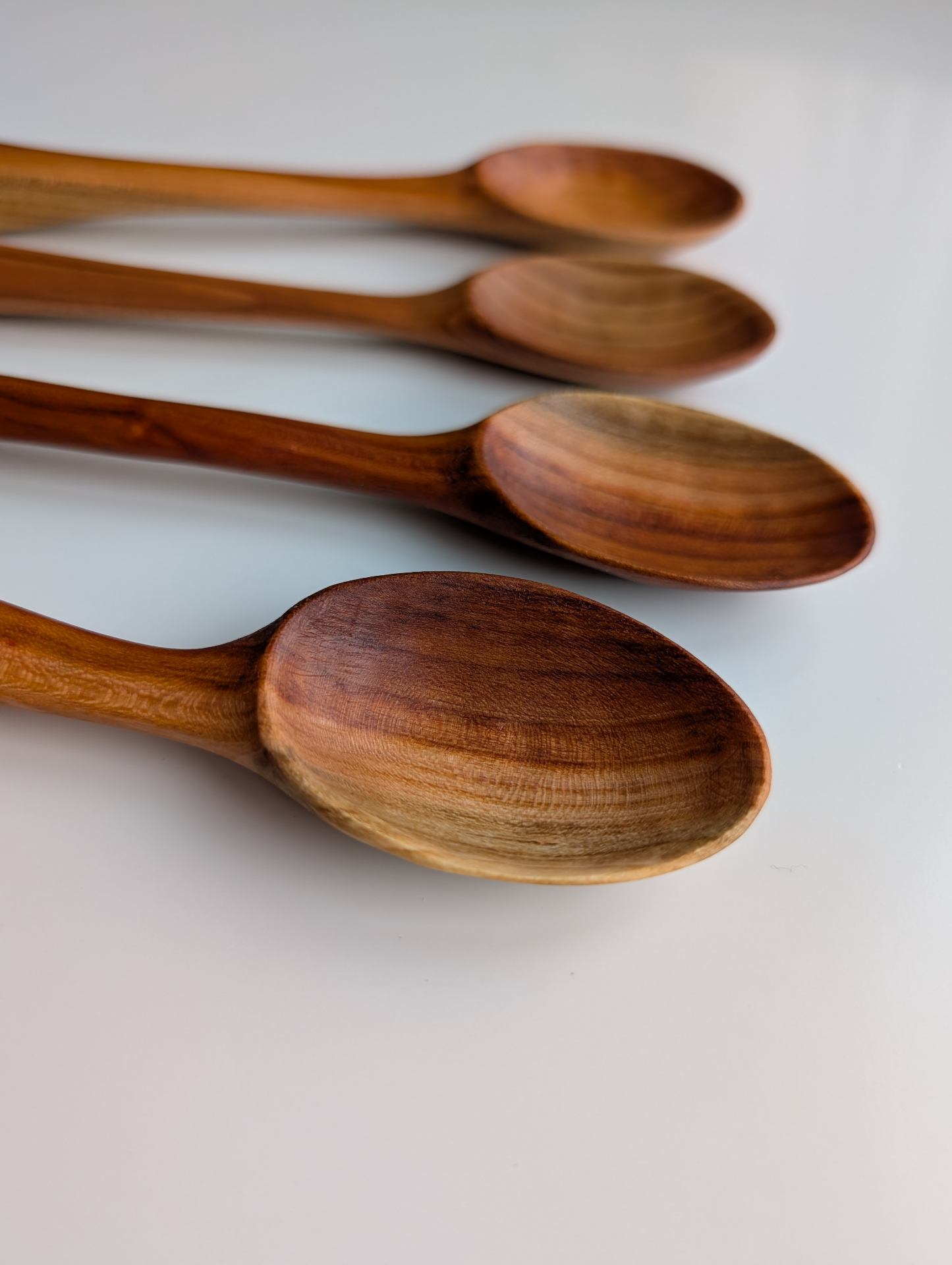 Close-up detail of hand-carved spoon bowls showing grain and finish
